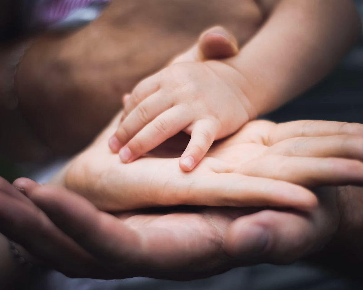 Forældre og barns hænder mødes, symbol på forældre til neurodivergente børn